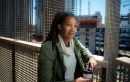 Provost Angela Booker stands on a rooftop with Eighth College construction happening behind her.