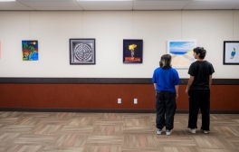 Two guests view the Visual Art Group’s 20th annual show at Price Center.