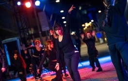 A group of contemporary dancers under colorful lights