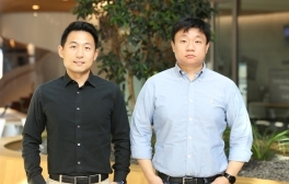 Alan Liu and Lu Yin stand next to each other in front of the Institute for the Global Entrepreneur in Franklin Antonio Hall.
