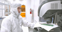 Video: Picture of a researcher at a microscope in a clean room suit