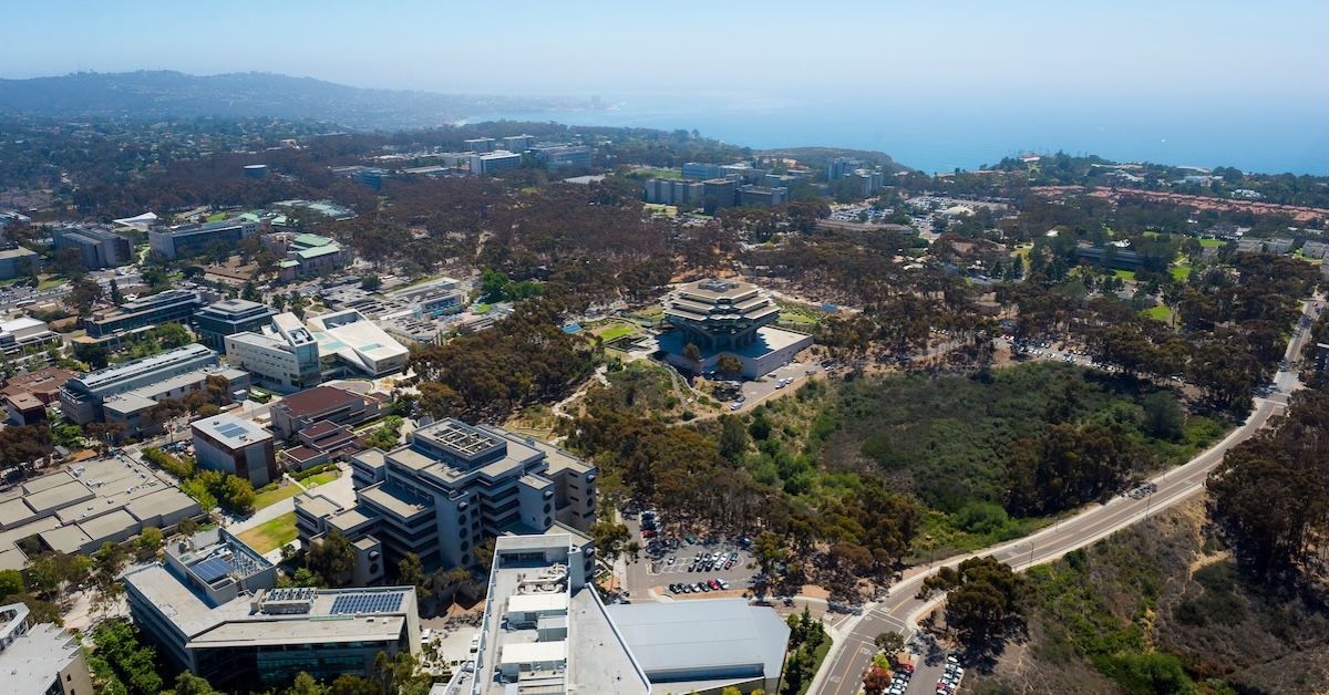 Aerial of UC San Diego with Geisel Library at center and the ocean in the background. 