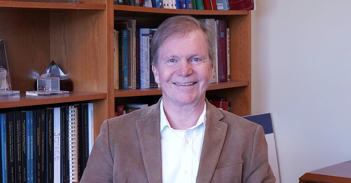 Bernhard Palsson in front of bookshelf