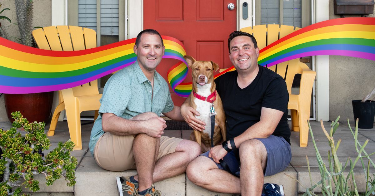 Justin Meyer sits with his husband and their dog on their front porch.