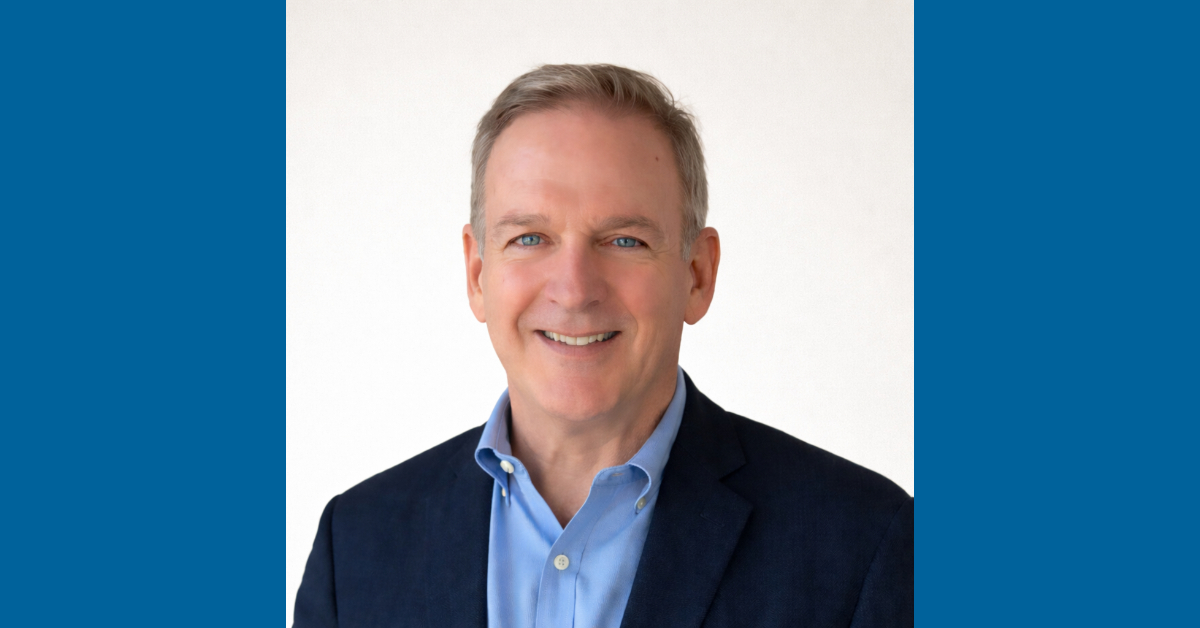Older white man wearing a light blue shirt and dark suit jacker
