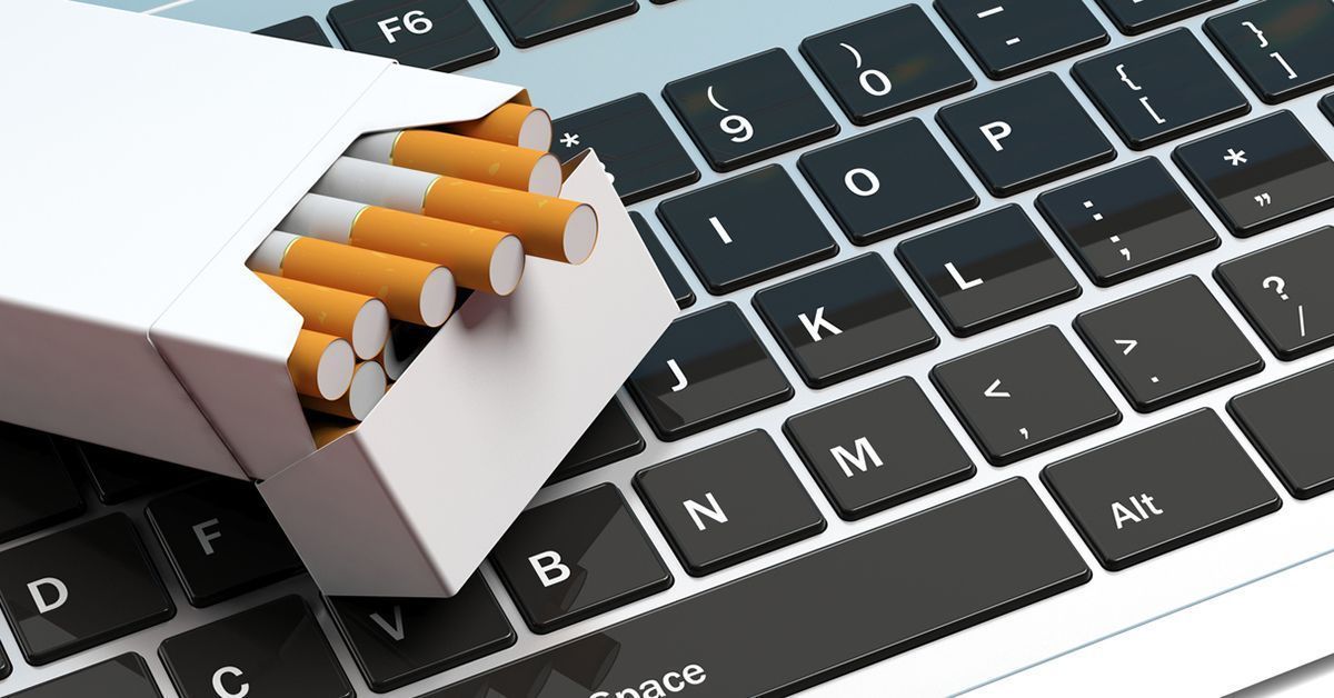 Pack of plain white cigarette pack sitting on top of keyboard.