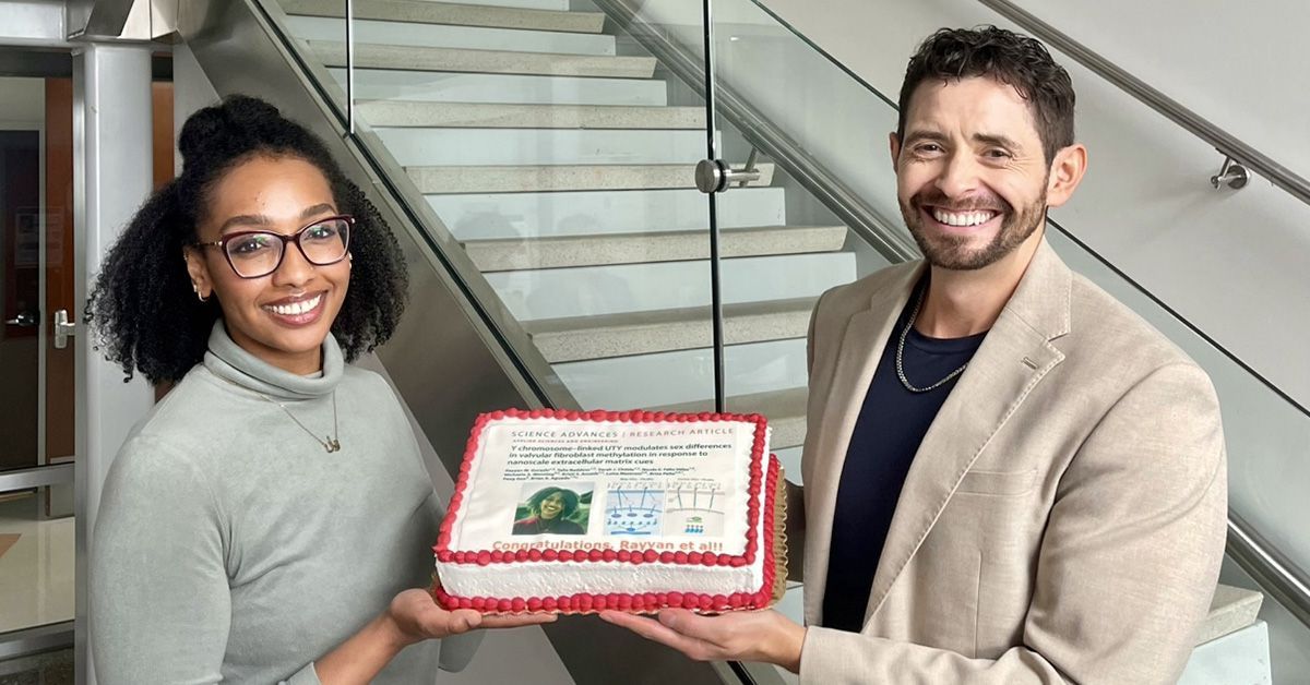 Two people holding a cake.