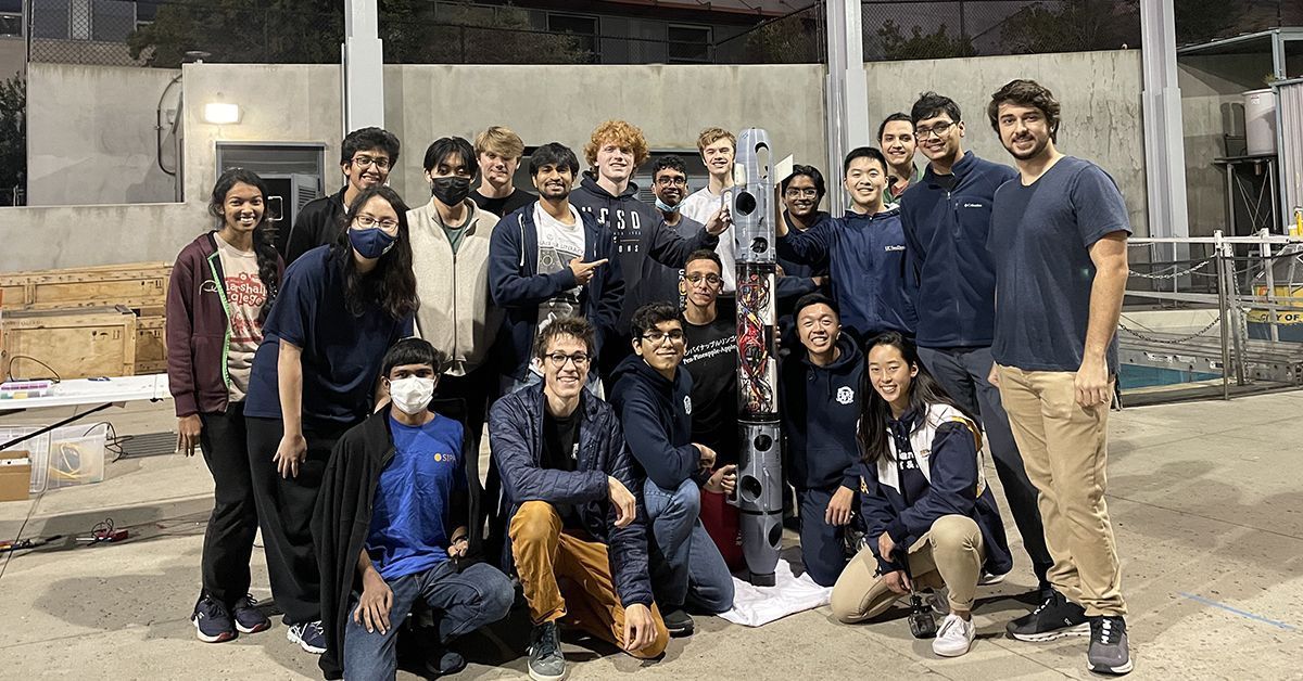 A group of undergraduate students poses with their autonomous underwater vehicle. 