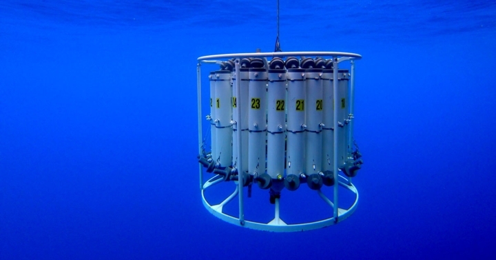 An oceanographic instrument known as a CTD is shown underwater.