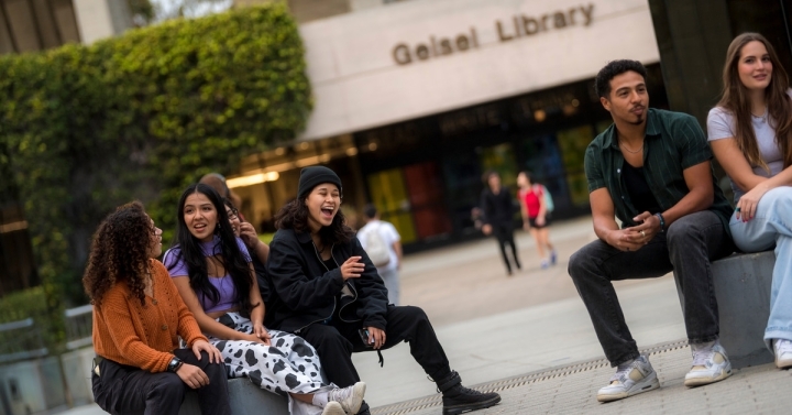 Students relax out front of Geisel Library. 