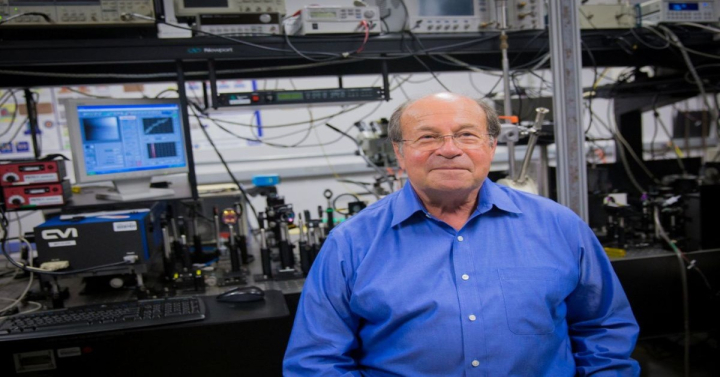 Professor Fainman standing in front of a lab bench covered with wires at his lab. 