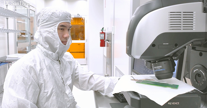 Video: Picture of a researcher at a microscope in a clean room suit