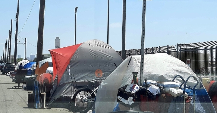 An encampment made of tents in which people experiencing homelessness live on a San Diego street.