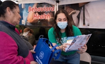 Dr. Argentina Servin shares pamphlets containing COVID-19 vaccine information with a patient.