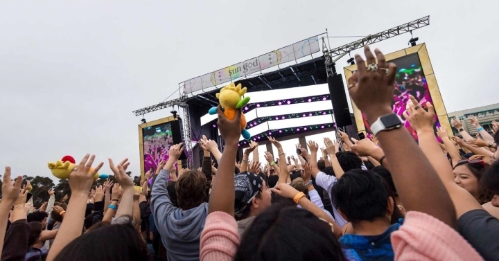 A crowd of students cheering in front of a stage.