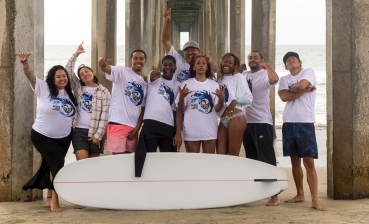 Black Surf Week participants gather on the beach for a group photo. 