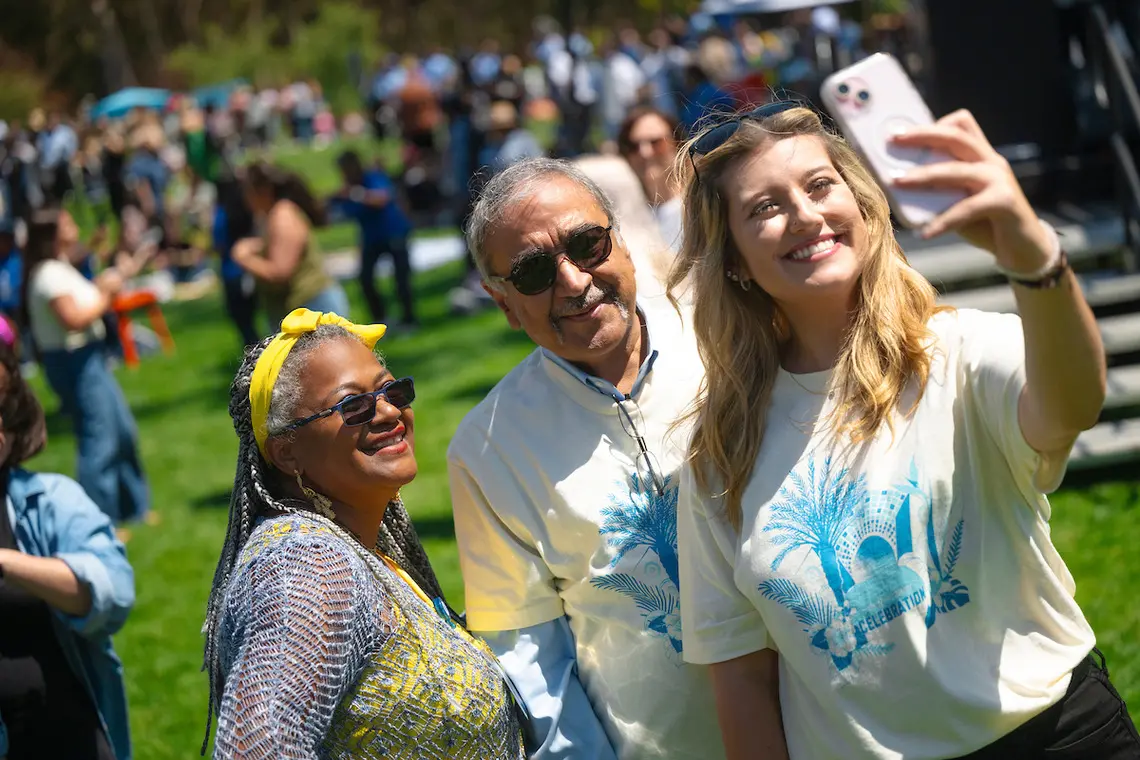 Chancellor Pradeep K. Khosla takes a selfie with two staff members.