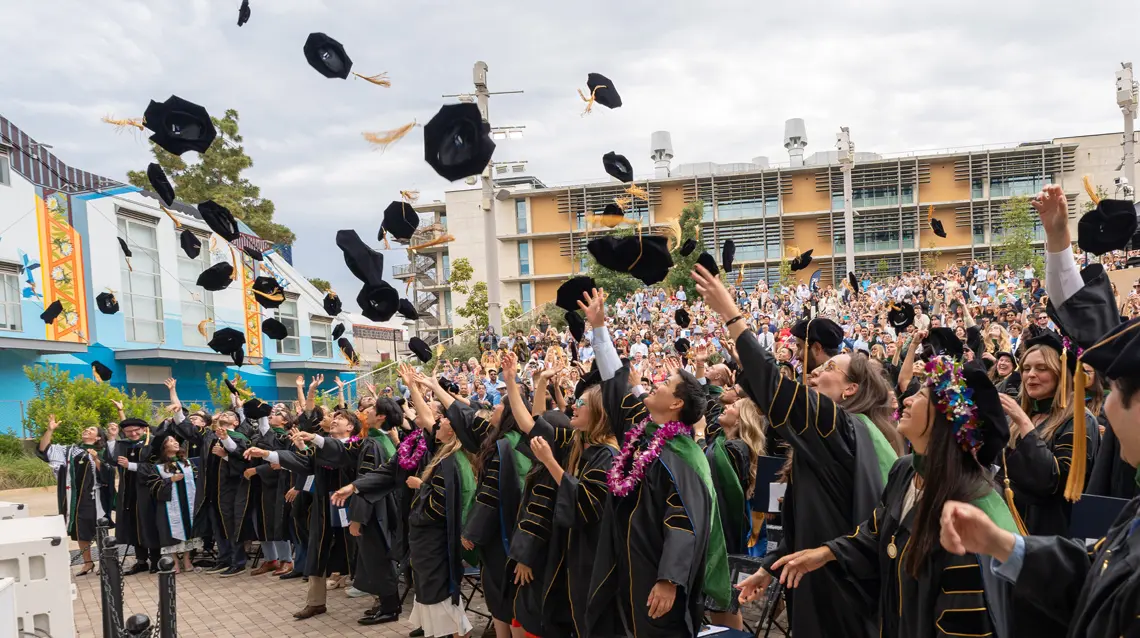 Group photos of medical school graduates tossing their caps into the air in celebration