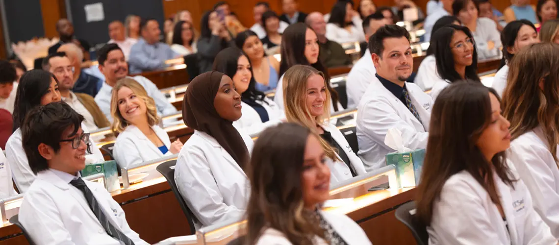 PA program students sitting in Ong Family Auditorium after receiving white coats