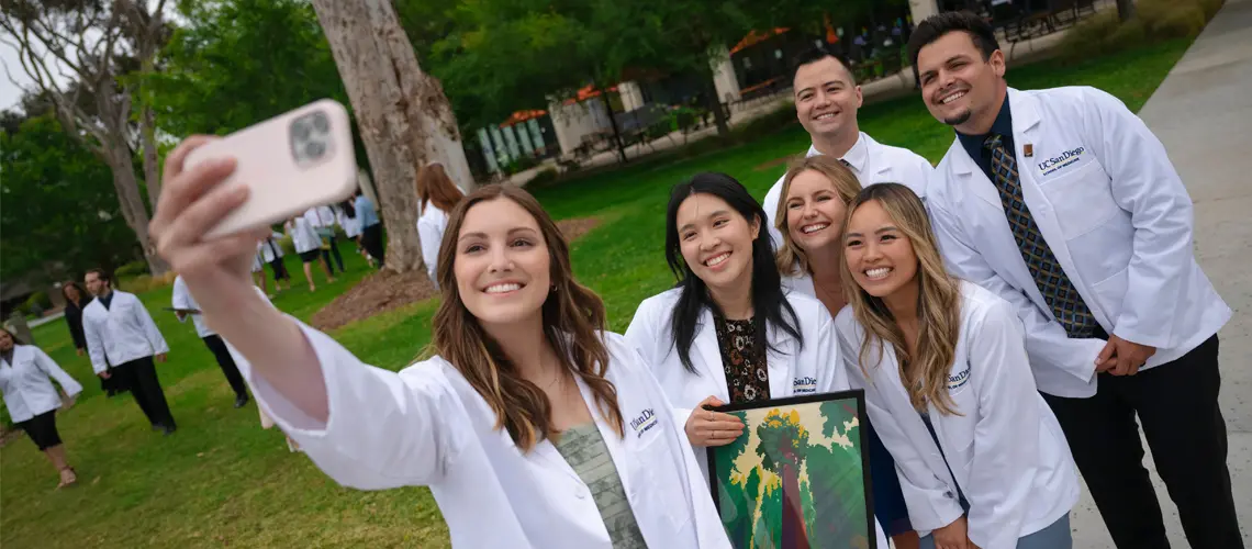 Group of six PA students taking a selfie wearing their white coats