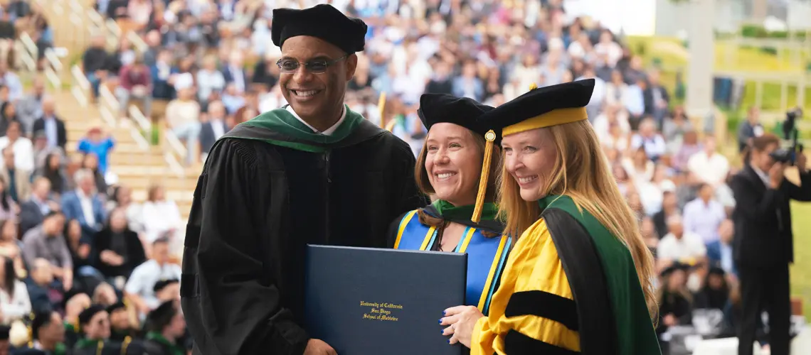 John M. Carethers, M.D., vice chancellor of Health Sciences and Michele M. Daniel, M.D. vice dean for Medical Education with student commencement speaker, Shelby Warren, M.D.