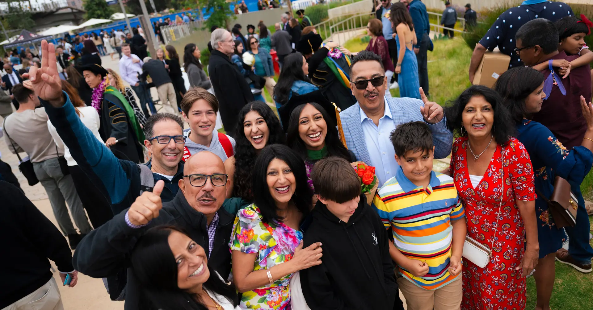 Female School of Medicine graduate smiling surrounded by family and friends