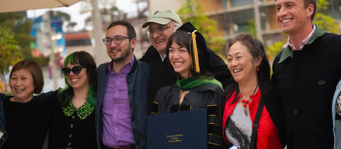 Female School of Medicine graduate posing with her family