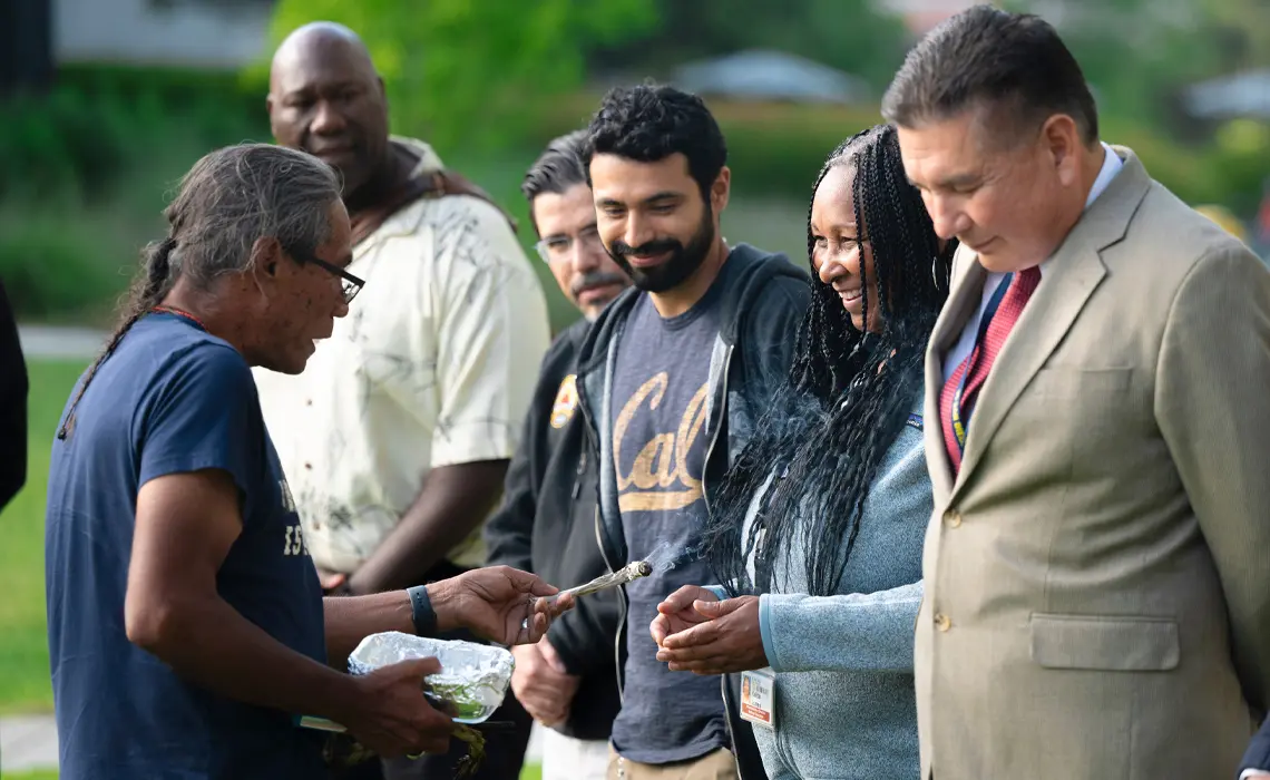 Stanley Rodriguez, Ed.D providing blessings to a group of people standing in a circle.