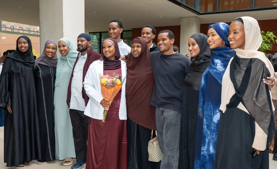 Female student of Somalian decent smiling and posing surrounded by family members