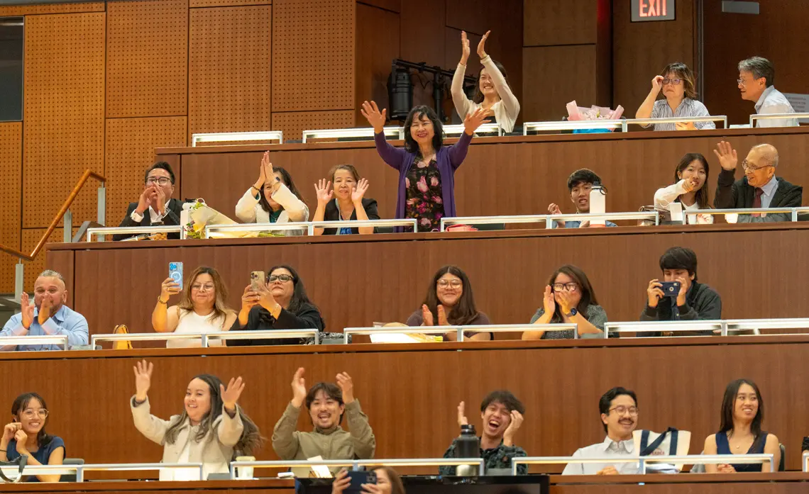 Family members clapping and cheering in the Ong Family Auditorium