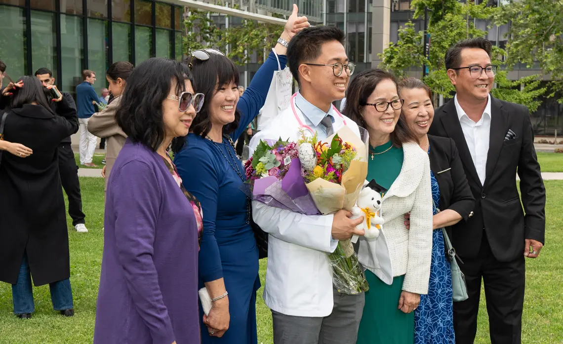 Side angle shot of a male student surrounded by smiling family members