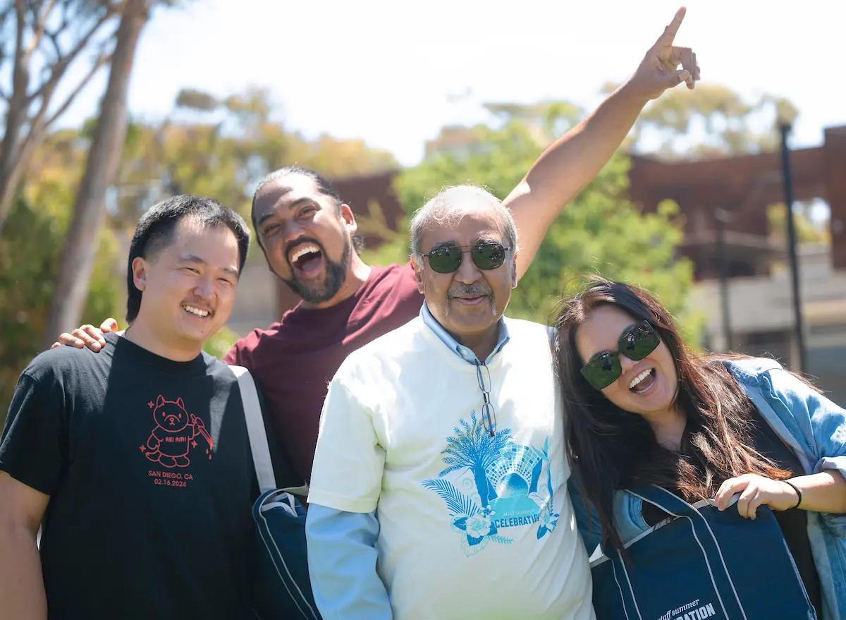 Chancellor Pradeep K. Khosla takes a photo with three staff members.