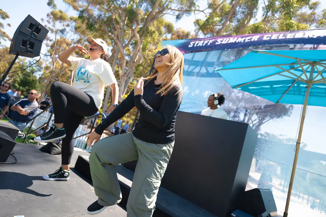 UC San Diego dance instructor leading the crowd alongside an attendee.