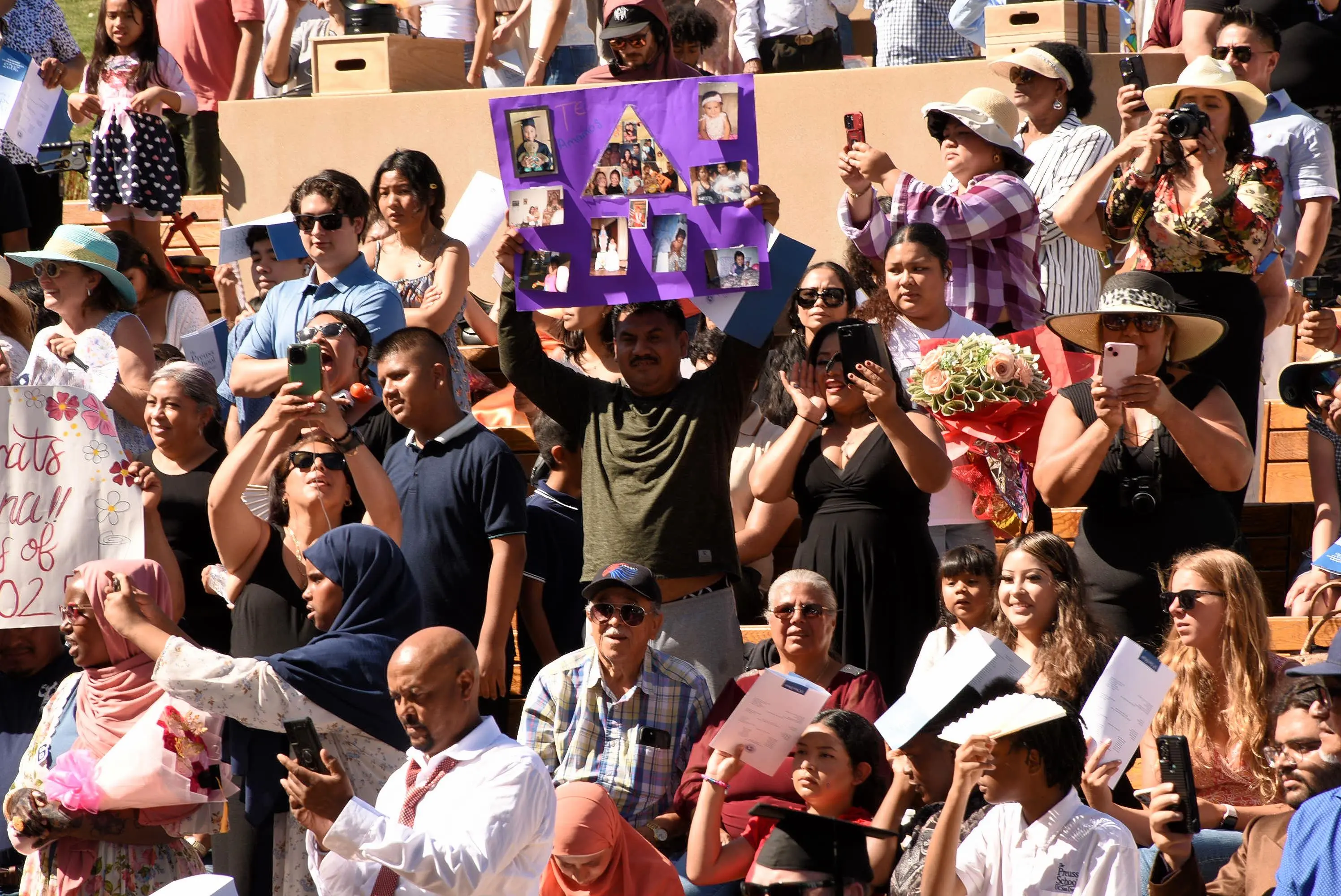person holds up a posterboard in the crowd