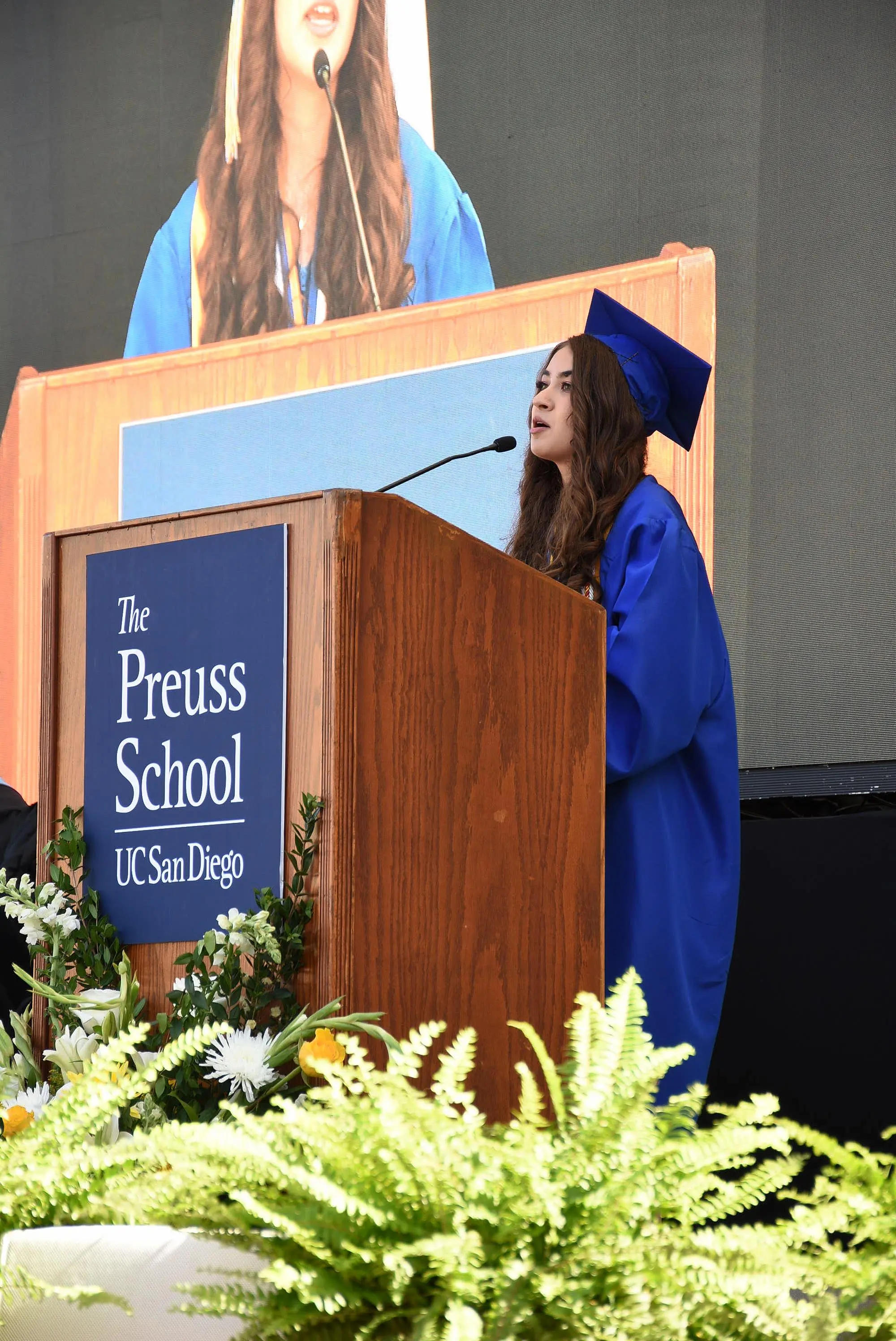 graduate stands and speaks at podium