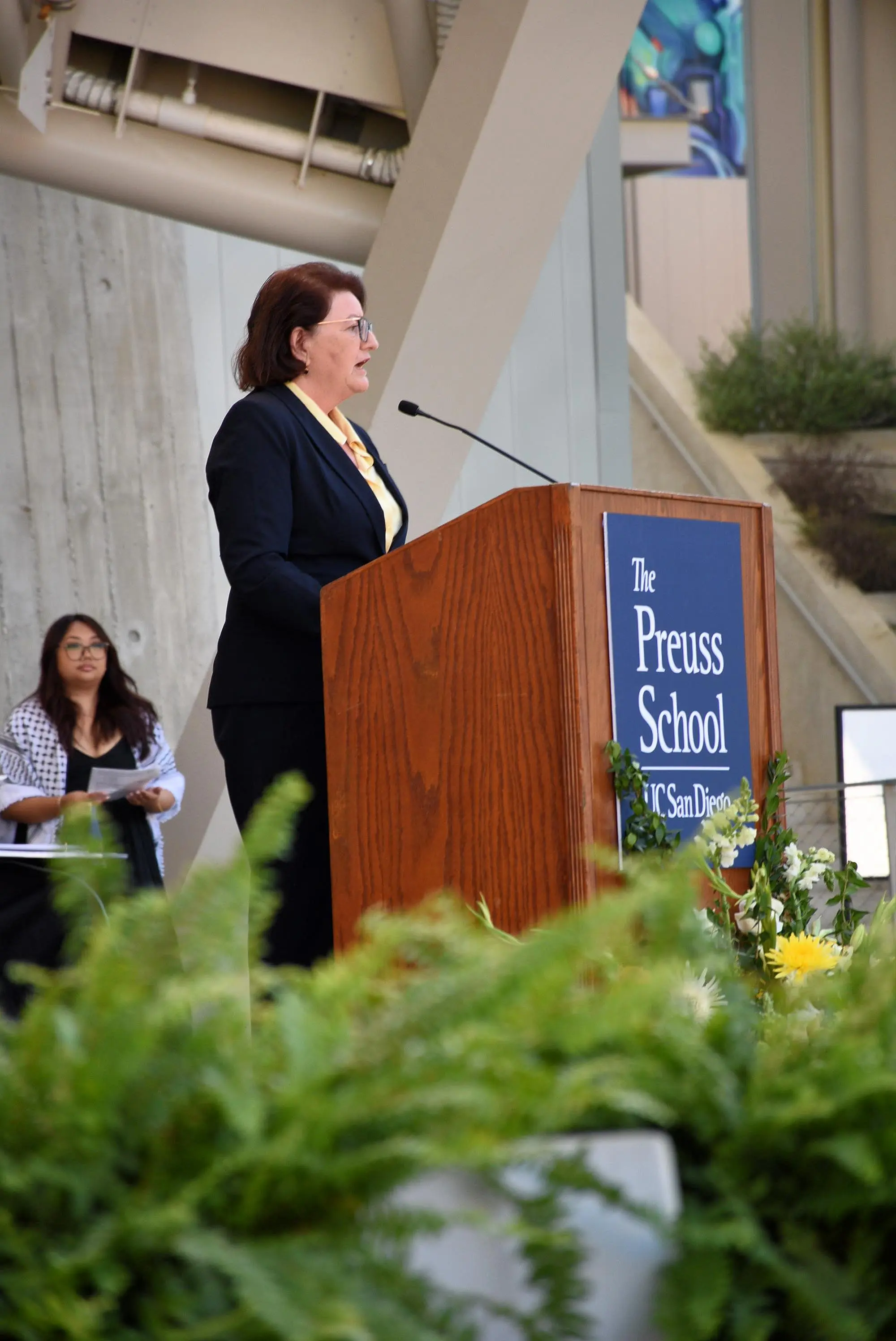 person stands and speaks at podium