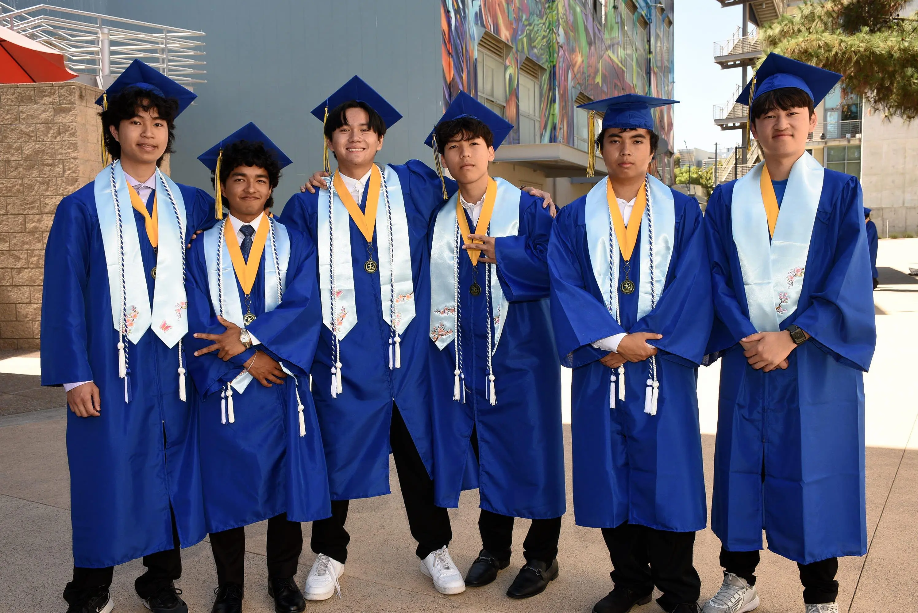 six students smile and pose at camera