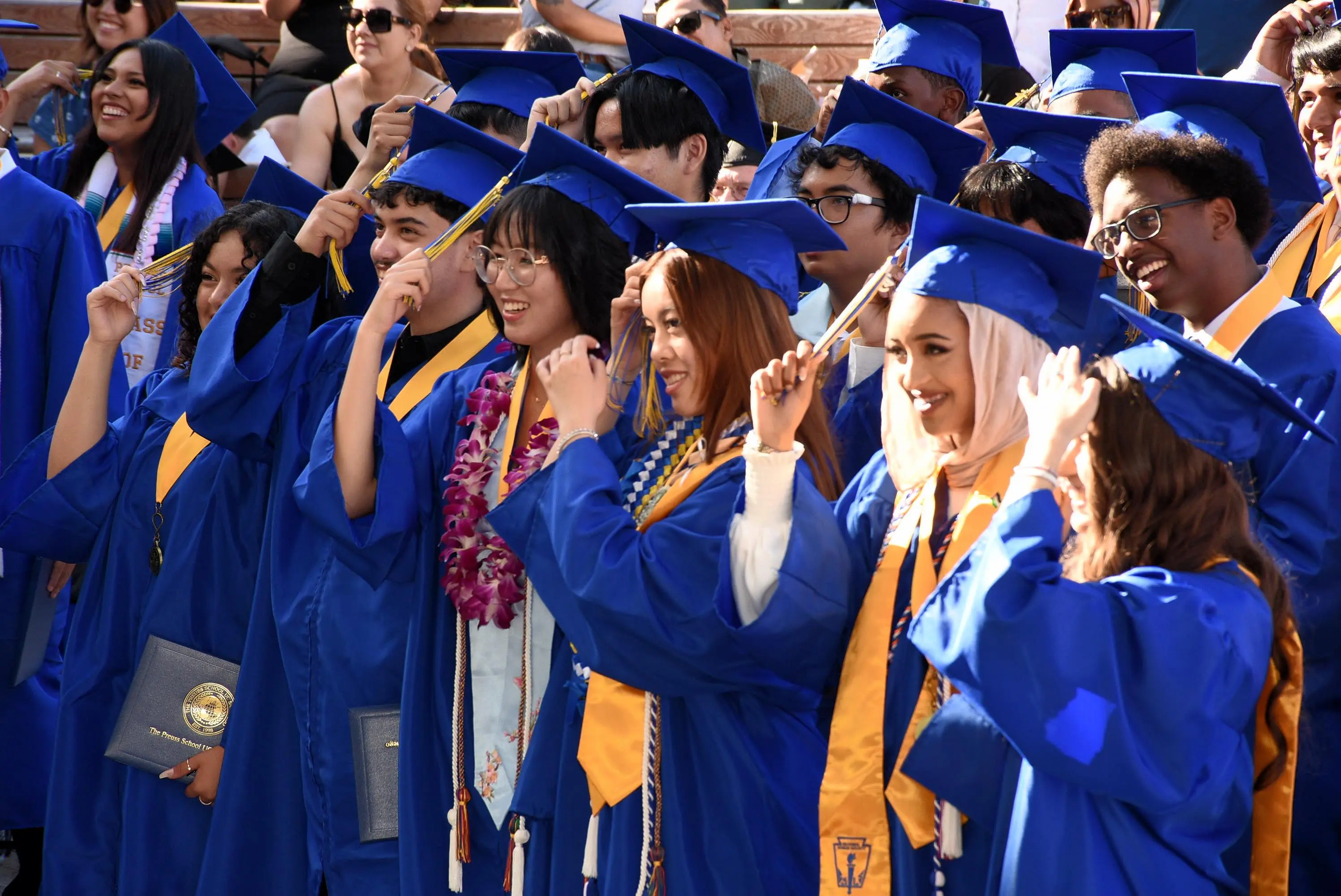 group of students move tassels from one side of their hat to the other