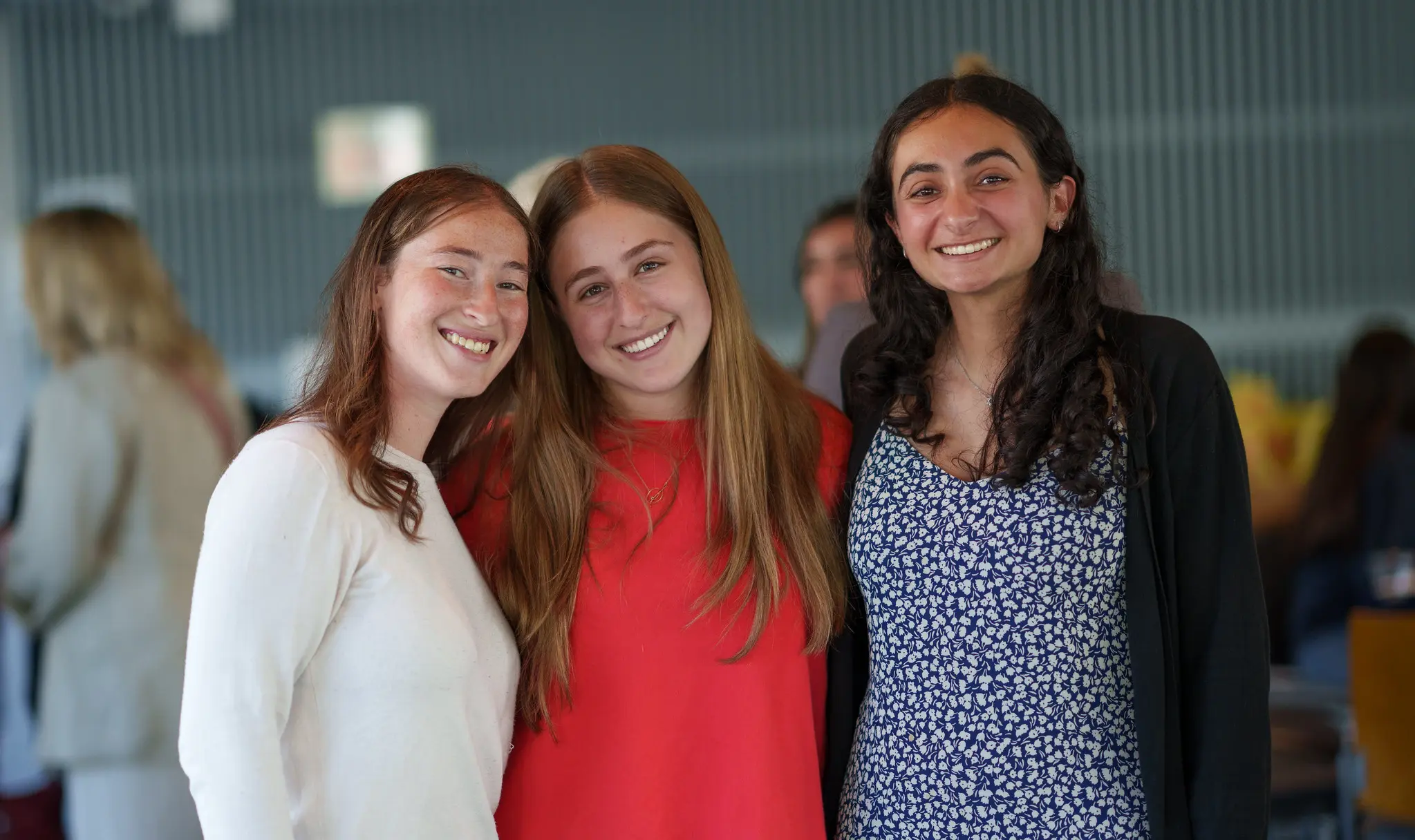 Three students smile at camera