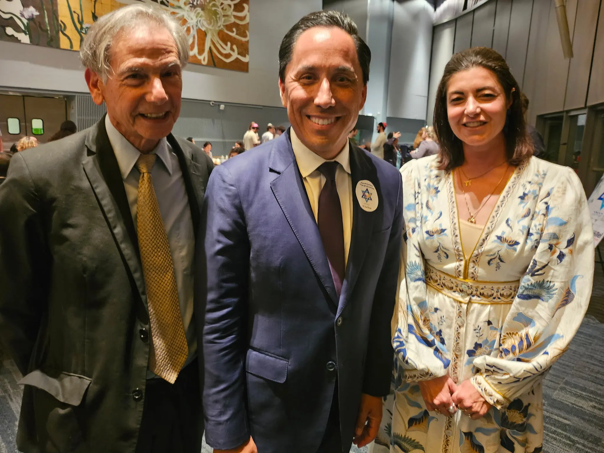 Three people smile at camera