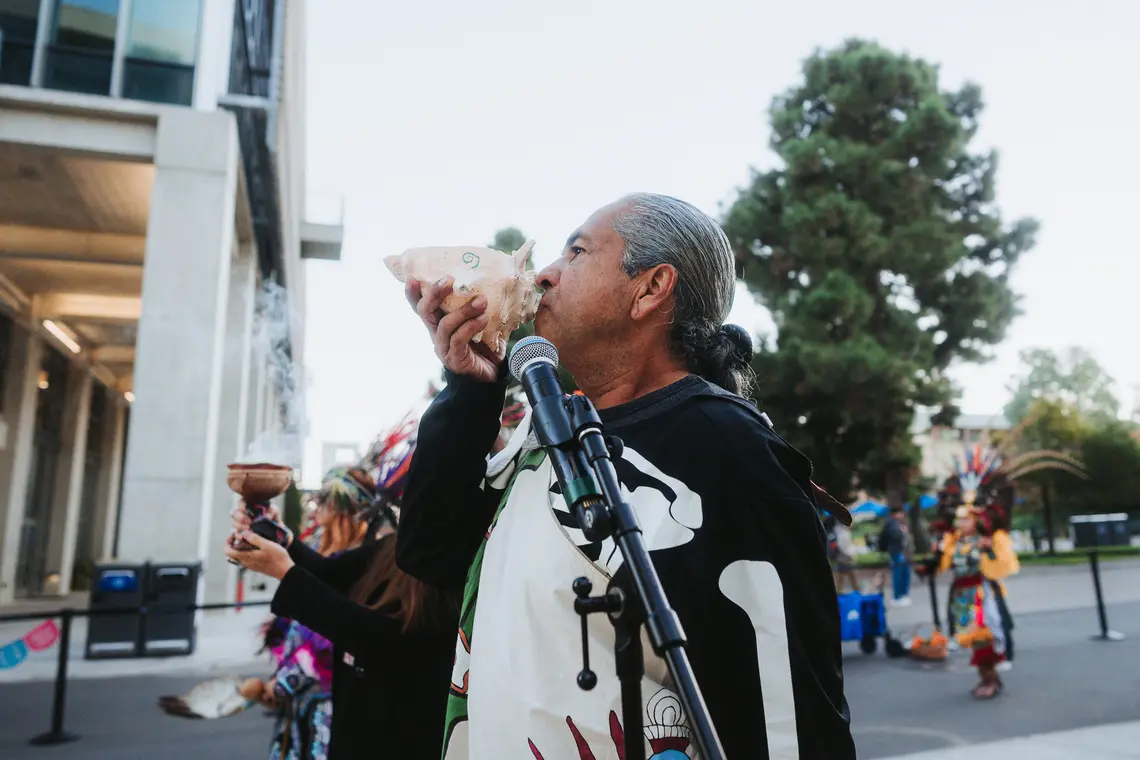 Program leader blowing into a conch