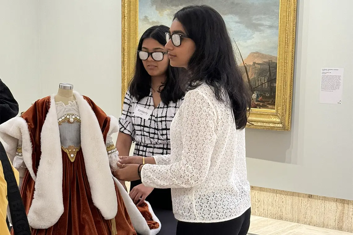 students at museum touching dressing, part of demostration