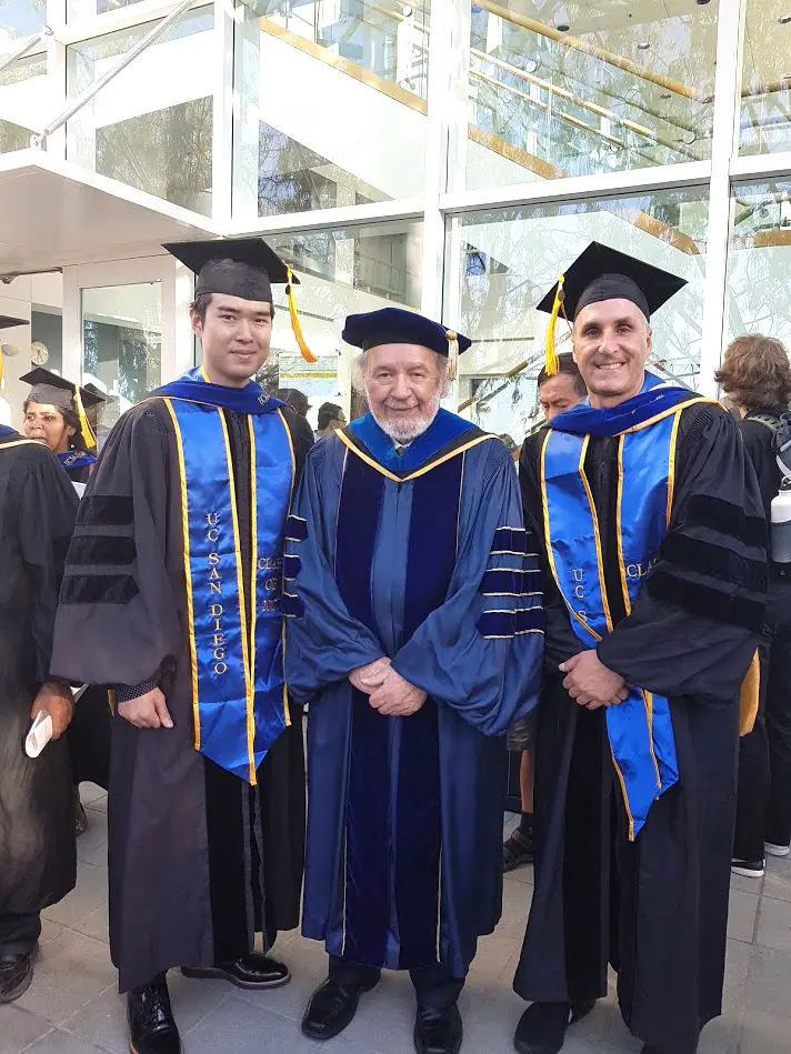 Brian with two male graduates in cap and gown