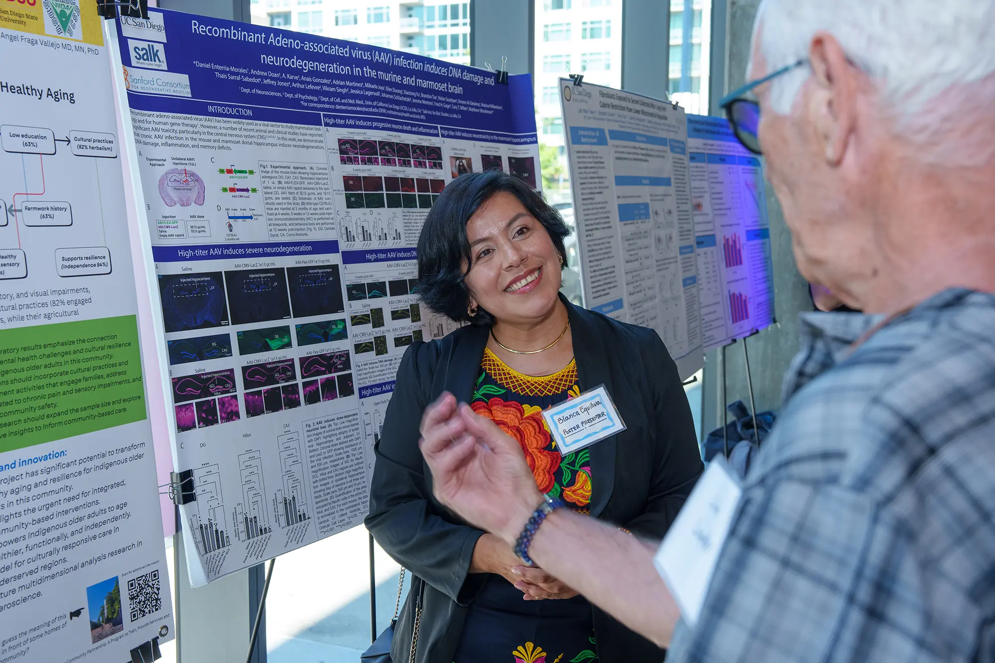 Female is engaged with older gentleman asking questions at the poster board section 