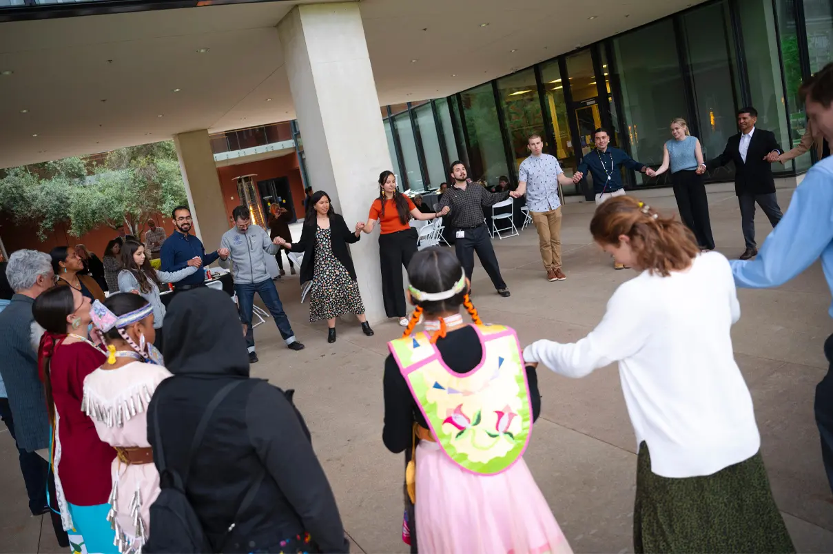 Students, faculty, staff and guests participating in a traditional round dance