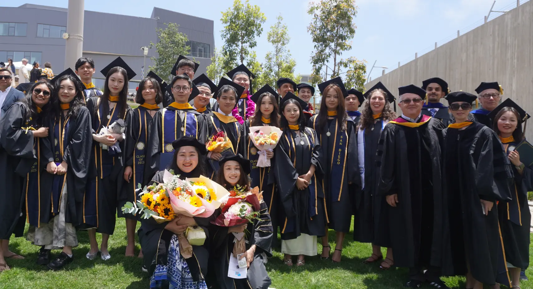 Graduates of the Master of Science (MS) and Doctor of Philosophy (PhD) programs in a group photo wearing their graduation regalia