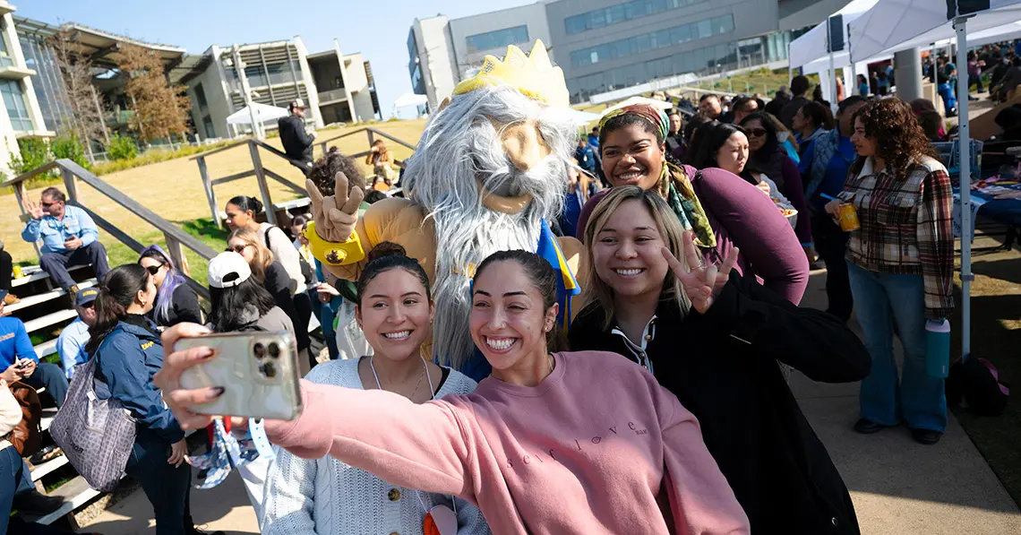 Four people take selfie with King Triton