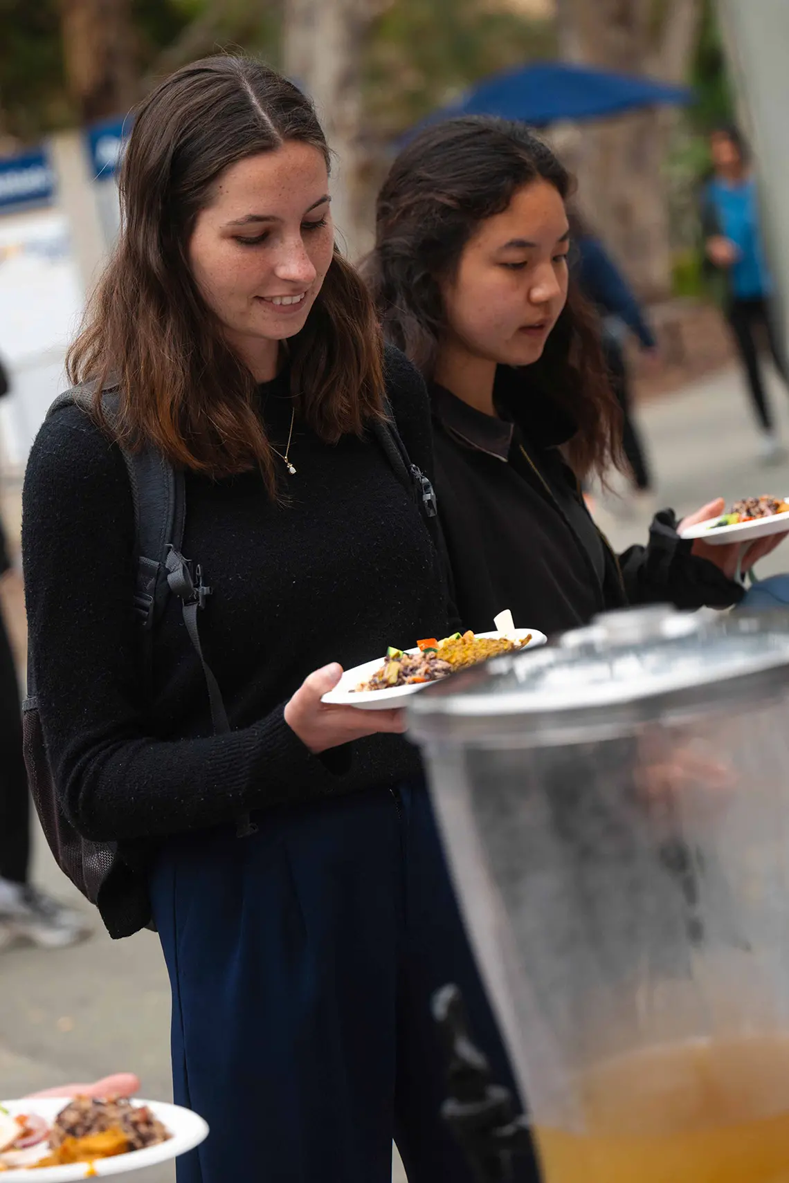 Students hold plates of food