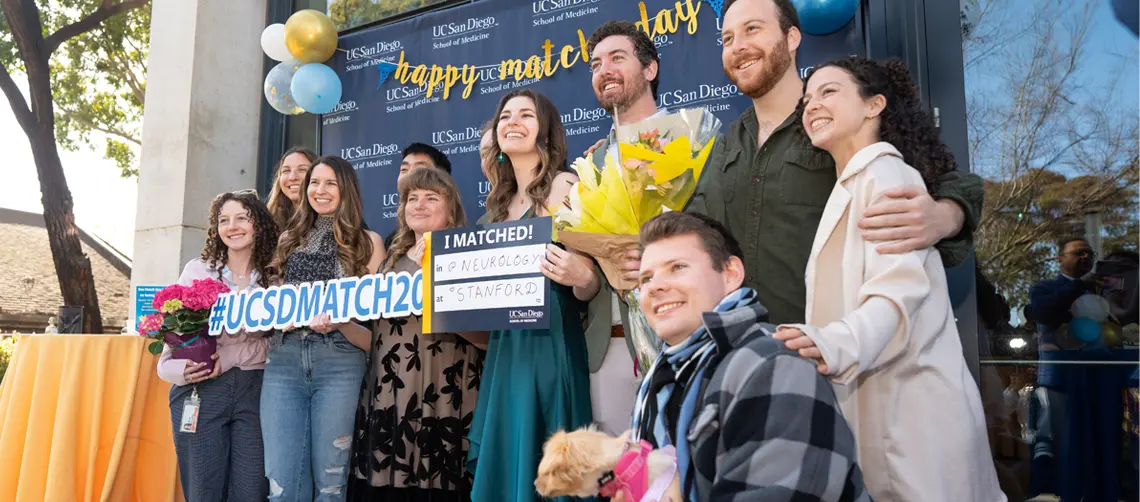 female medical student surrounded by large group of family and friends