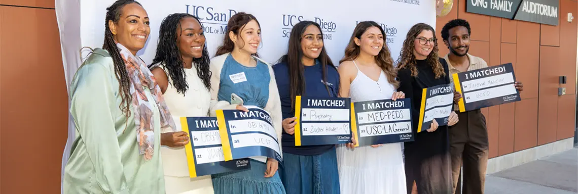 Group photo of Global Health Academic Community students with Match Day signs